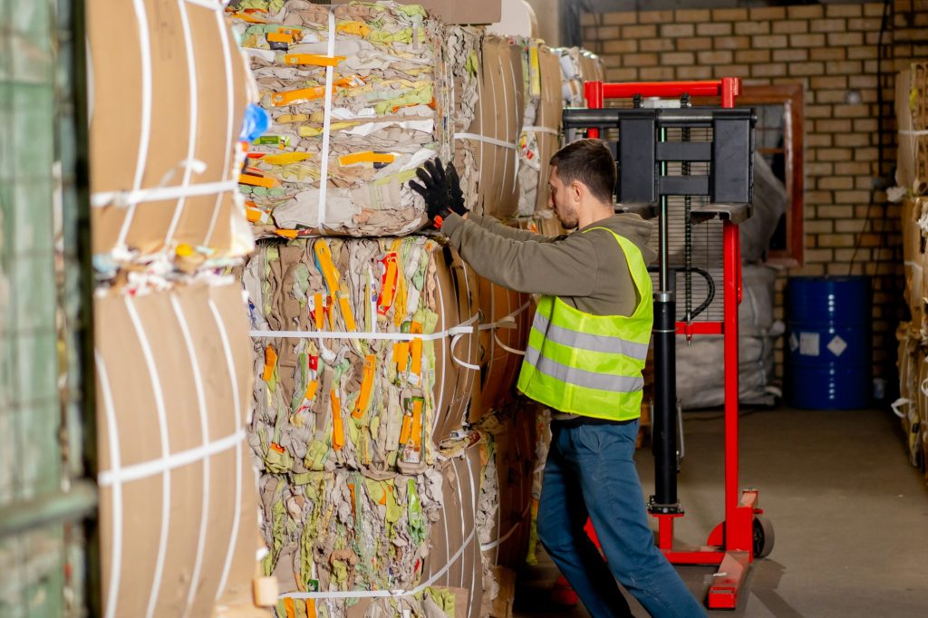 A worker at a waste treatment station takes out a large box of things at waste treatment center